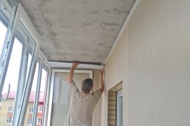 Мастер устанавливает ПВХ панели на потолок